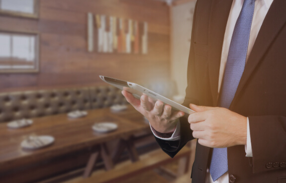 Man in hospitality looking at a digital tablet